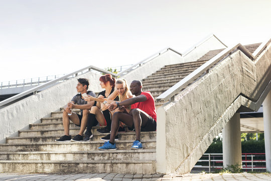 Young runners in the city sitting on the stairs.
