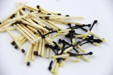 A bunch of burnt and whole matches on a white background