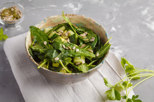 Green vegan kale, cucumber, sunflower seeds salad. Healthy vegetarian detox food concept.