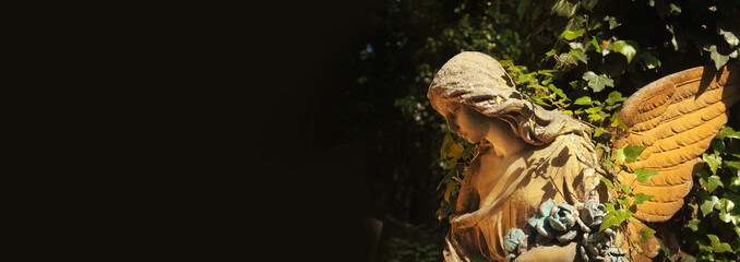 Antique statue of gold angel in the sunlight with place for text and designer. (religion, faith,...