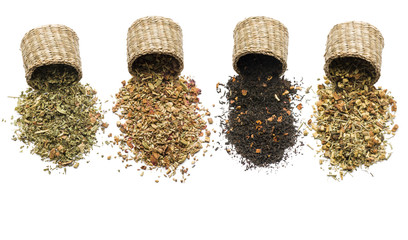 variety of tea blend in straw baskets on white background