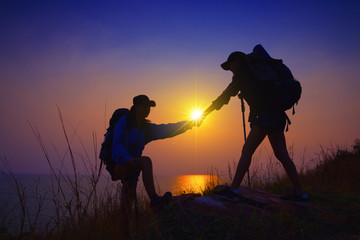 Fototapeta premium Young asian couple climbing up on the mountain,hiking and team work concept.