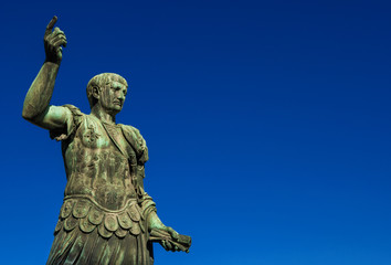 Fototapeta na wymiar Trajan the conqueror, one of the greatest ancient roman emperor, bronze statue along Imperial Fora avenue in the very center of Rome (with copy space)