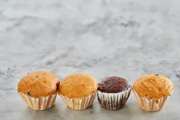 Tasty muffins arranged in pattern on light textured background, close-up, shallow depth of field, selective focus.