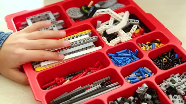 Closeup view of child's hand and many details for constructing robots. Real time full hd video footage.