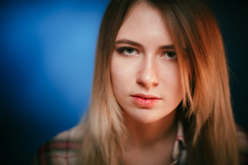 Obraz premium portrait smiling girl on blue background in studio