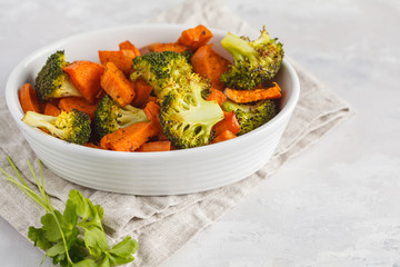 Baked broccoli and sweet potato with spices in white dish. Vegan Healthy Food Concept.
