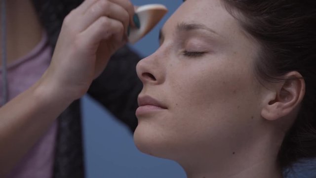 Make up artist applying foundation with a cotton pad