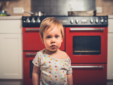 Little boy in kitchen by the stove
