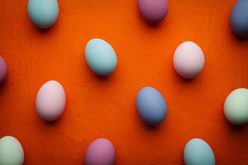 Fototapeta na wymiar Easter background - colored eggs on orange table