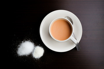 Milk Tea with sugar,creamer and tea leaf on the wooden table.Visible Noise,Blur when view at Full Resolution.