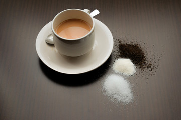 Milk Tea with sugar,creamer and tea leaf on the wooden table.Visible Noise,Blur when view at Full Resolution.