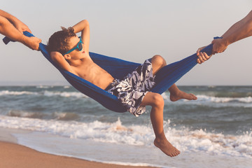 Happy little boy relaxing on the beach at the day time