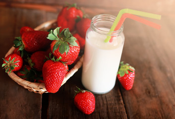 wooden table with strawberries and milk in a glass 