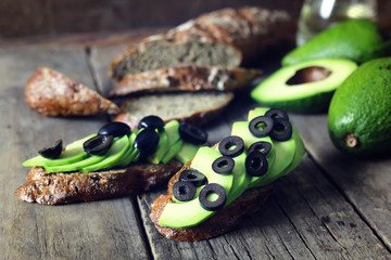 avocado bread olives on a wooden background