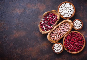 Assortment of various beans in wooden bowls 