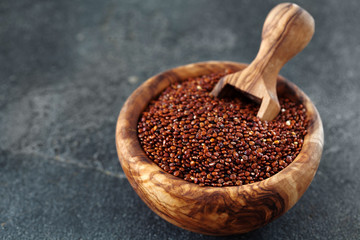 Seeds of red quinoa in wooden bow copy space