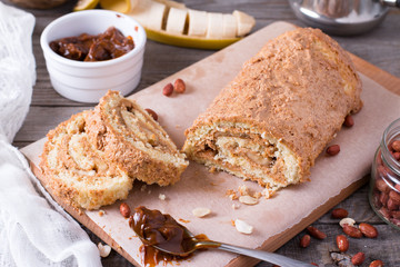 Homemade biscuit roll with cream, banana and peanuts