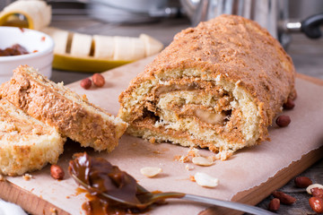 Homemade biscuit roll with cream, banana and peanuts