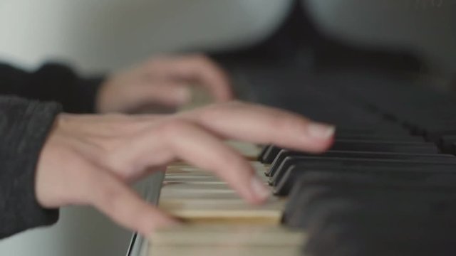Girl playing the piano in her room, arpeggios with left hand.