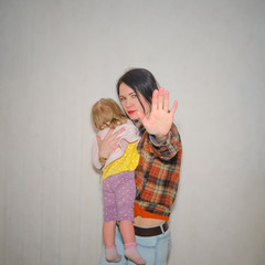 the girl protects the child, hand gesture stop on a gray background