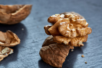 Top view close-up shot of cracked walnuts on dark background, shallow depth of field, macro