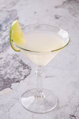 perfect classic margarita, white alcoholic cocktail with decoration of salt on the edge of the glass with lime, lemon, daiquiri on gray background restaurant. Bar alcohol menu, sweet drink.