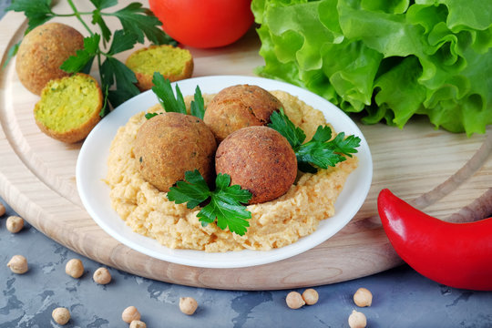 Falafel balls and bowl with hummus on cutting board. Vegetarian and vegan healthy food.