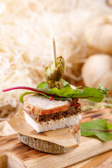 Canape with boiled pork on a woody background with micro green. Rustic.