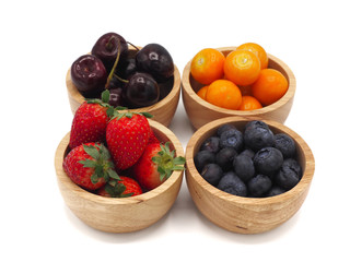 Fresh summer fruits, Cherry, strawberry, cape gooseberry and blueberry in wooden bowl isolated on white background.