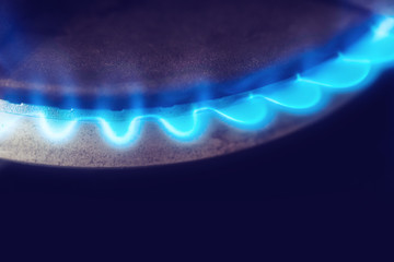 Gas burner flame at gas stove in the dark, close-up