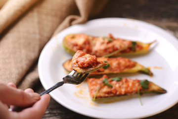 Baked stuffed zucchini with meat on a plate.
