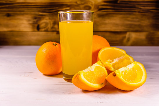 Oranges and glasses with orange juice on a wooden table
