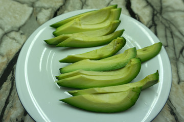 Cutted avocado and lime on white .