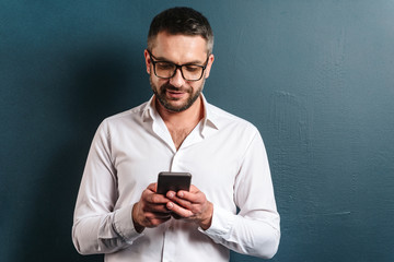 Cheerful man wearing glasses chatting by phone.