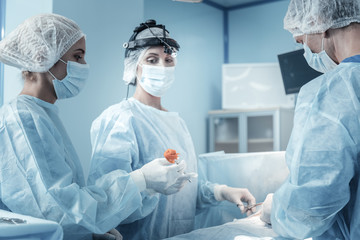 Supersede it. Reliable serious concentrated nurse standing in the operational doing her work and...