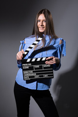 Smiling young woman with movie clapper