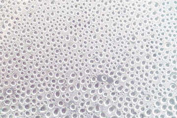 Drops on the glass, white abstract background, texture