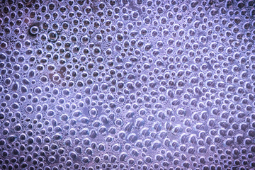 Drops on the glass, purple abstract background, texture