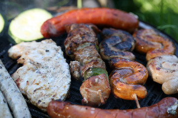 A set of meats baked on the grill during a family picnic in free time. Summer relaxation in the open air.