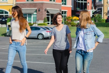 Happy young Asian women group city lifestyle playing and chatting each other among the pastel building city on weekend. City lifestyle of girls group. City lifestyle and outdoor activity concept.