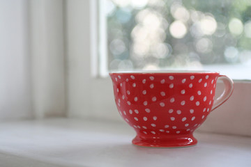 Red coffee cup on window bokeh background © panchanok