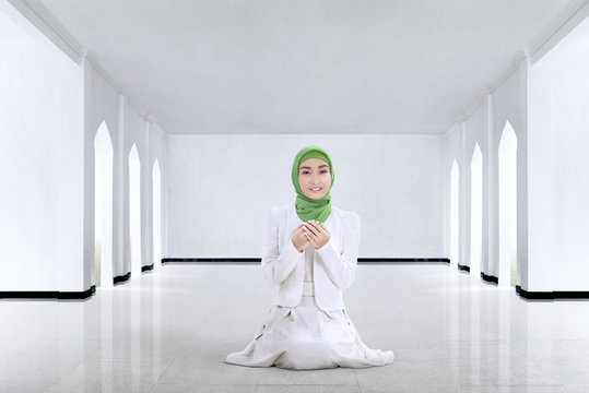Pretty asian muslim woman praying to god