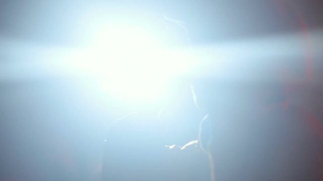 Side view of rap singer on live concert in the night club / hip-hop band singing bright light flash flare music underground musician collective festival emotional moving