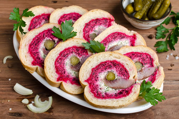 Obraz na płótnie Canvas Sandwich with herring fillet, onion, pickled cucumber, cream cheese and beetroot