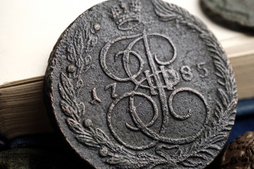 copper coin of the Russian Empire against the background of an open book close-up