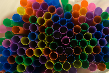 colored flexible straws in the glass isolated on white background .