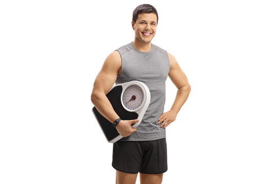 Young man in sportswear holding a weight scale