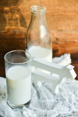 glass of milk, cow on natural wooden background in rustic style, rural style, concept of natural products and farming