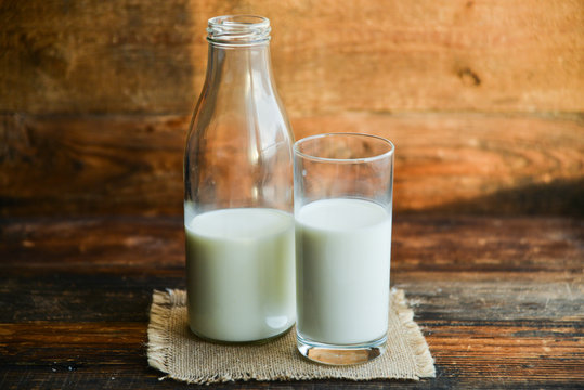 glass of milk, cow on natural wooden background in rustic style, rural style, concept of natural products and farming